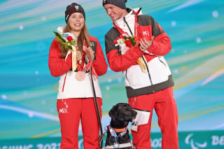 Illustration de l'article : Jeux paralympiques : une skieuse de fond autrichienne gravit les marches du podium et offre une médaille à son chien guide (vidéo)