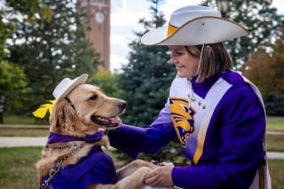 Illustration de l'article : En accompagnant sa maîtresse sur le terrain, ce chien d’assistance est devenu la star de la fanfare universitaire (vidéo)