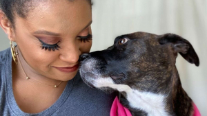 Illustration : Une femme émue par le regard triste d’un chien maltraité par le passé, tente de lui apporter son aide